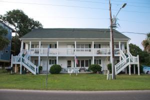 a large white house with a porch and a sign at True North - A Beach & Boat Lover's Dream in Carolina Beach