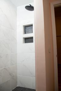a shower with white tile and a window at True North - A Beach & Boat Lover's Dream in Carolina Beach