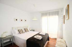 コルノデイヤにあるApartaments la Rambla - L'Arrel - 4 personesの白いベッドルーム(ベッド1台、窓付)