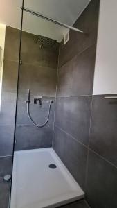 a bathroom with a shower with a glass door at Warzalas Apartement in Bergkamen
