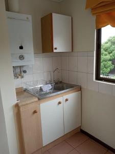 una pequeña cocina con fregadero y ventana en Apart Hotel Sendero del Sol, en La Serena