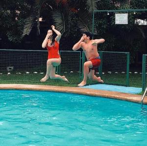 un hombre y una mujer parados junto a una piscina en Apart Hotel Sendero del Sol, en La Serena