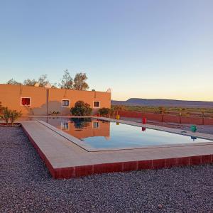 una casa con piscina di fronte a un edificio di LESCALE DE OUARZAZATE a Ouarzazate