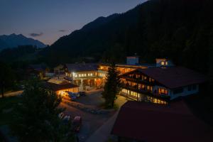 una vista de un hotel por la noche con las luces encendidas en Geisler-Moroder en Elbigenalp