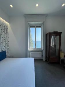 una camera con un letto bianco e una finestra di Villino Saraceno Rostain a Borgio Verezzi