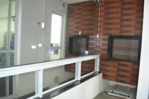 Pokój z ceglaną ścianą i oknem w obiekcie Apartamento Praia do Santinho w mieście Florianópolis