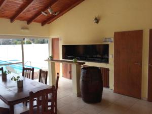 a living room with a table and a large screen tv at Duplex del Sol in Villa Carlos Paz