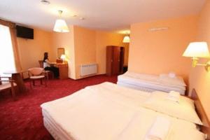 a hotel room with two beds and a woman sitting at a desk at OKRĄGLAK Residence Sosnowiec in Sosnowiec +18 photos
