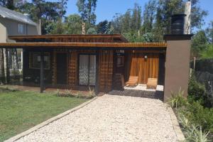 una casa con un porche con 2 sillas en Casa de Playa en el Bosque en Mar del Plata