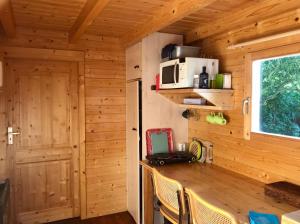 una cocina en una cabaña de madera con mesa y sillas en Klein Langeveld en Noordwijkerhout