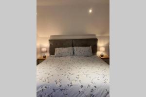 um quarto com uma cama com um edredão branco em Phil's Cottage Sleeps 2 one dog by prior permission em Barnard Castle