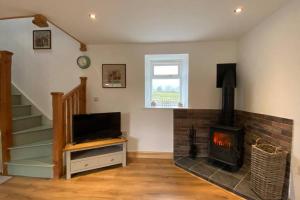 a living room with a fireplace and a television at Phil's Cottage Sleeps 2 one dog by prior permission in Barnard Castle