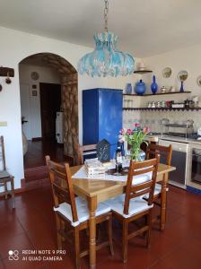 a kitchen with a wooden table with chairs and a chandelier at Il Piccolo Giardino in Perinaldo