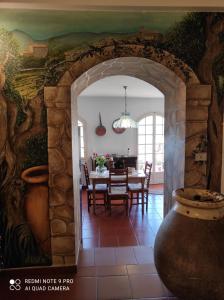 a kitchen and dining room with a table and a stone wall at Il Piccolo Giardino in Perinaldo