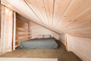 a small room with a bed in a wooden cabin at Дом LBerry Брусника у Ладоги in Sortavala