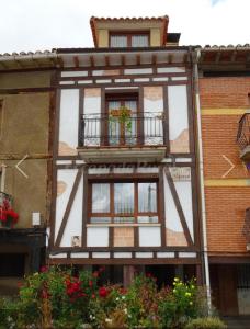 - un bâtiment avec deux fenêtres et un balcon dans l'établissement El soportal, à Barbadillo del Pez