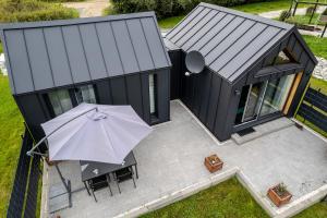 - une vue sur une maison noire avec un parasol dans l'établissement ViewMountain domek z 1 sypialnią., à Jelenia Góra
