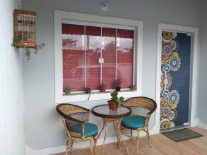 a table and chairs in a room with a window at Casa com Jardim na Praia de Guaratiba, Maricá in Maricá