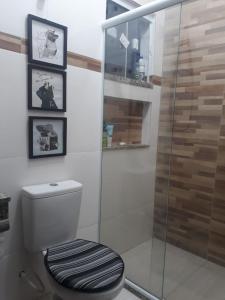 a bathroom with a toilet and a glass shower at Casa com Jardim na Praia de Guaratiba, Maricá in Maricá +19 photos