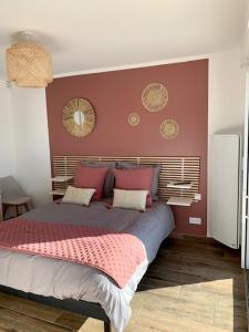 a bedroom with a large bed with red walls at Les Chambres de Lily 1 in Lorgies