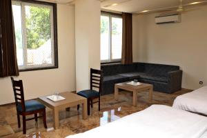 Rājsamandにあるhotel keshav innのベッド2台とソファが備わるホテルルームです。