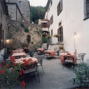 un patio al aire libre con mesas y sillas en un edificio en Villa Vezza, en Capolona