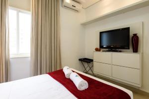 ein Schlafzimmer mit einem Bett und einem Flachbildfernseher in der Unterkunft Estilo em Ipanema - Boa localização - VP305 Z2 in Rio de Janeiro