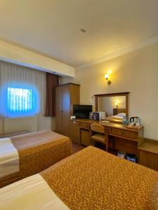 ein Hotelzimmer mit 2 Betten und einem Schreibtisch in der Unterkunft Monark Hotel Cappadocia in Nevşehir