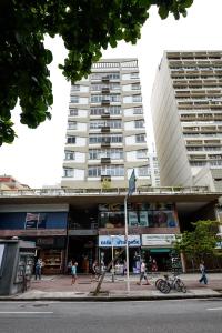 Ein hohes weißes Gebäude mit Leuten, die davor laufen. in der Unterkunft Estilo em Ipanema - Boa localização - VP305 Z2 in Rio de Janeiro