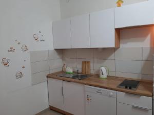 uma cozinha com armários brancos e uma bancada em Guest House Renata em Zadar
