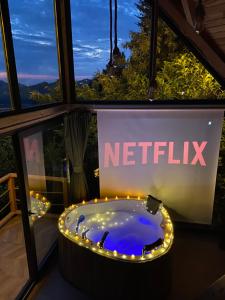 a bath tub with lights in front of a netflix sign at Pavri suit bungalov in Ardeşen