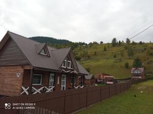 a house with a fence in front of a hill at "Файна хата" in Synevyrsʼka Polyana