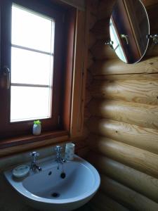 ein Bad mit einem Waschbecken, einem Spiegel und einem Fenster in der Unterkunft Osiers Country Lodges in Diss
