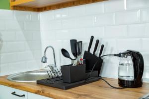 a kitchen counter with a knife holder next to a sink at Evergreen Apart in Almaty
