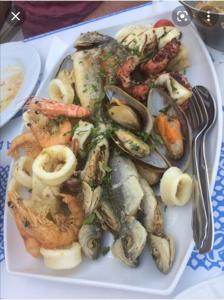 a plate of food with seafood and shrimp on a table at Apartment by the Sea,Neoi Epivates Beach, Thessaloniki in Neoi Epivates