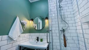 a bathroom with a sink and a shower with a mirror at Evergreen Apart in Almaty +43 photos