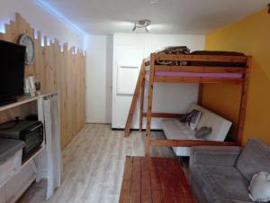salon z 2 łóżkami piętrowymi i kanapą w obiekcie STUDIO en PLEINE MONTAGNE AVEC VUE SUR MARMOTTES w mieście La Mongie