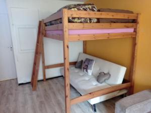 Ce lit superposé se trouve dans un dortoir doté d'un canapé. dans l'établissement STUDIO en PLEINE MONTAGNE AVEC VUE SUR MARMOTTES, à La Mongie