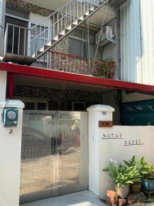 een glazen deur van een gebouw met een trap bij Guan Ma Homestay in Miaoli