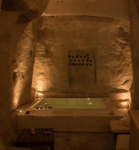 LA DIMORA DELLE 3 ZIE في ماتيرا: حمام مع حوض استحمام في كهف