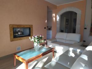 a living room with a vase of flowers on a coffee table at PianadiNavelliHouse2 in San Pio delle Camere