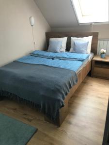 een slaapkamer met een groot bed met blauwe lakens en kussens bij Homoki Wellness Üdülőház in Balatonakarattya