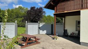 a patio with a wooden bench and a fence at B&B Haus Kristal in Walsdorf