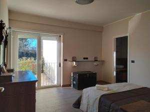 a bedroom with a bed and a sliding glass door at PianadiNavelliHouse2 in San Pio delle Camere