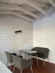 una mesa y sillas en una habitación con una pared blanca en Balka Eco Club, en Glubokaya Balka