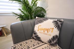 Una almohada con la palabra verano en ella sentada en un sofá en Full house, en Taitung
