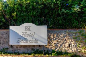 a sign for a hotel in front of a stone wall at Hotel Bellavista in Anacapri