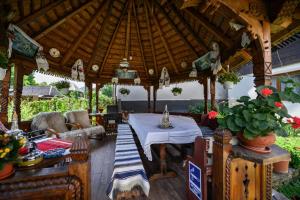 a wooden gazebo with a table and chairs at Pensiunea Denisa in Bîrsana