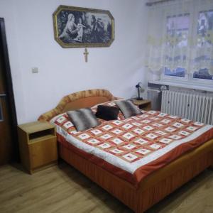 een slaapkamer met een bed en een kruis aan de muur bij Privat Ludmila in Liptovská Teplička