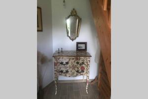 einen Flur mit einem Tisch und einem Spiegel an der Wand in der Unterkunft Studio meublé près des plages du débarquement in Émiéville